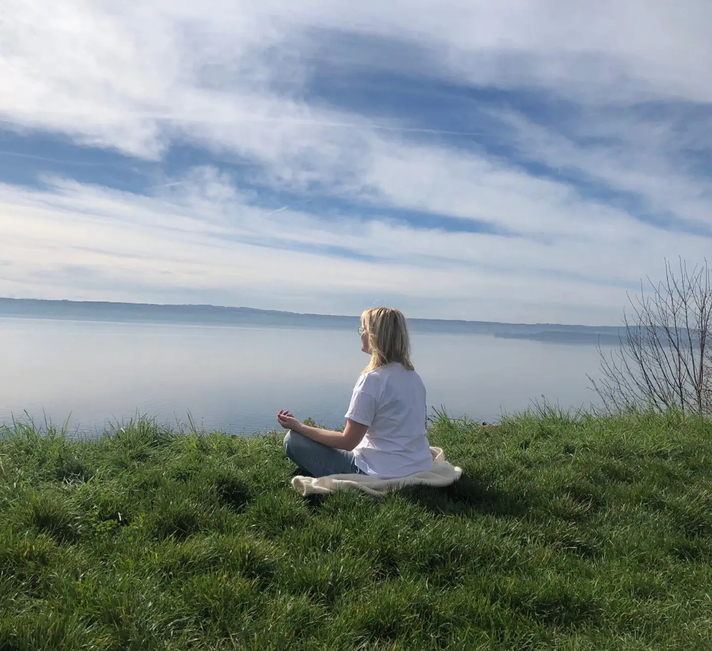 meditierende Frau mit blick auf einen See